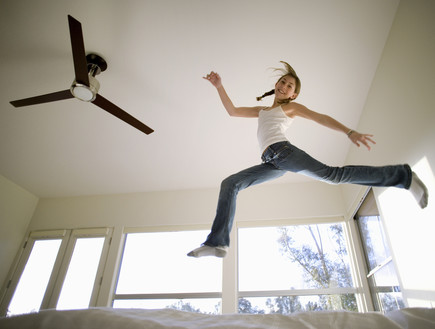 נערה קופצת באוויר ליד מאוורר תקרה (אילוסטרציה: Air Images, Shutterstock)
