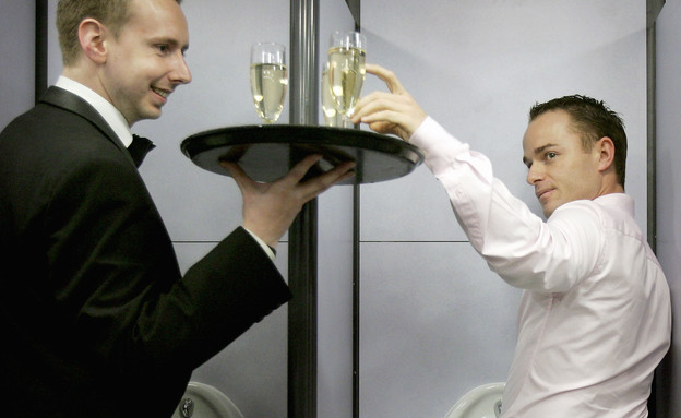 מלצר מגיש שמפניה למבקרים בשירותים בלונדון - Bruno Vi (צילום: Bruno Vincent, GettyImages IL)