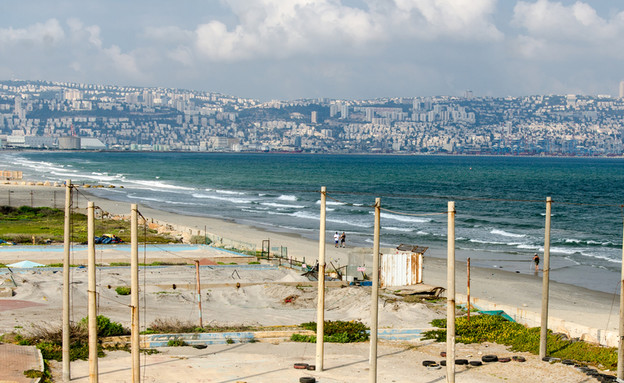 חוף ים נטוש בקריית ים על רקע העיר חיפה (צילום: Alex Lerner, Shutterstock)