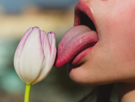 אישה  מלקקת פרח (צילום: Volodymyr Tverdokhlib, Shutterstock)