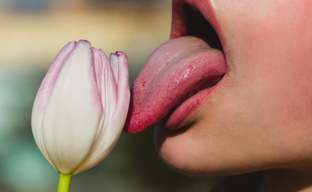 אישה  מלקקת פרח (צילום: Volodymyr Tverdokhlib, Shutterstock)