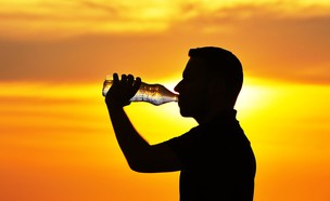 איש שותה בשקיעה (צילום: Jaromir Chalabala, Shutterstock)