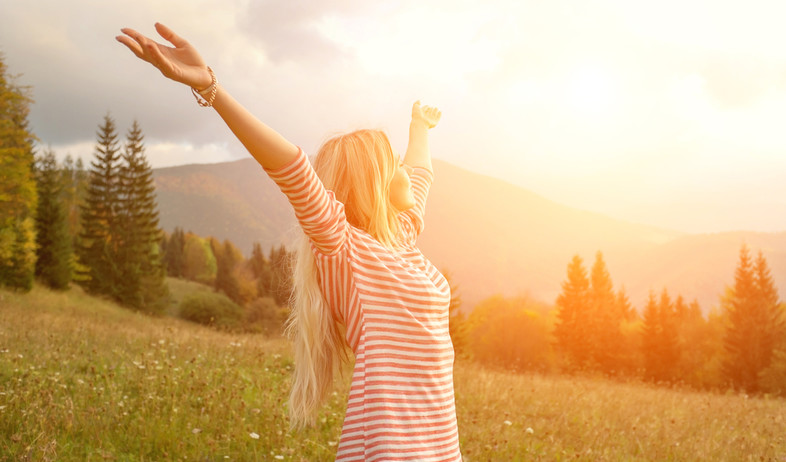 אישה שמחה בשקיעה (צילום: Shutterstock)
