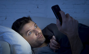 אילוסטרציה: גבר צופה בסמארטפון (צילום: ShutterStock)