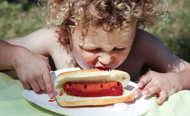 ילד אוכל נקניקייה (צילום: Olga Enger, Shutterstock)