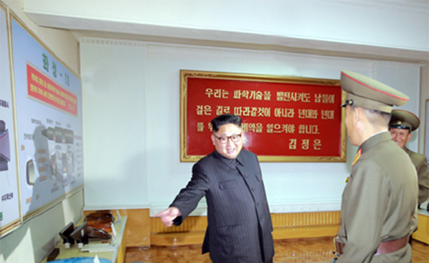 קים ותרשים הטיל החדש (משמאל) (צילום: התקשורת הקוריאנית)