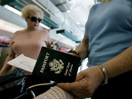 אישה מוציאה דרכון אמריקאי בשדה התעו (צילום: GettyImages - Sandy Huffaker)