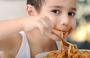 ילד אוכל ספגטי ומחייך (צילום: By Dafna A.meron)