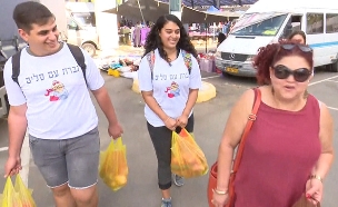 בני הנוער שעוזרים למבוגרים לערוך קניות בשוק (צילום: החדשות)