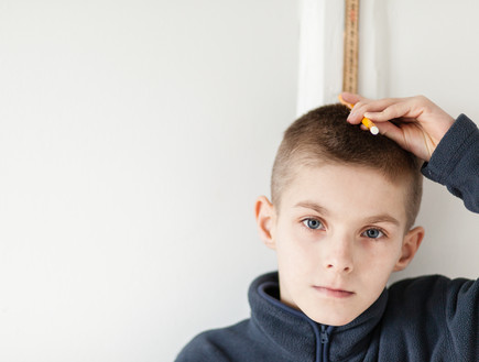 ילד מודד לעצמו את הגובה (צילום: Shutterstock/Jan H. Andersen)