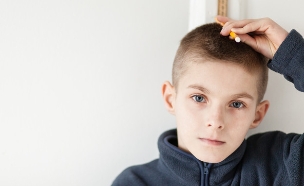 ילד מודד לעצמו את הגובה (צילום: Shutterstock/Jan H. Andersen)