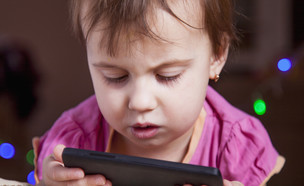 ילדה מרוכזת בסמארטפון (צילום:  Zwiebackesser, ShutterStock)