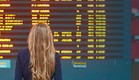 אישה עומדת מול לוח טיסות (צילום: Ekaterina Pokrovsky, Shutterstock)