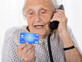 קשישה מדברת בטלפון ומחזיקה כרטיס אשראי (אילוסטרציה: By Dafna A.meron, shutterstock)