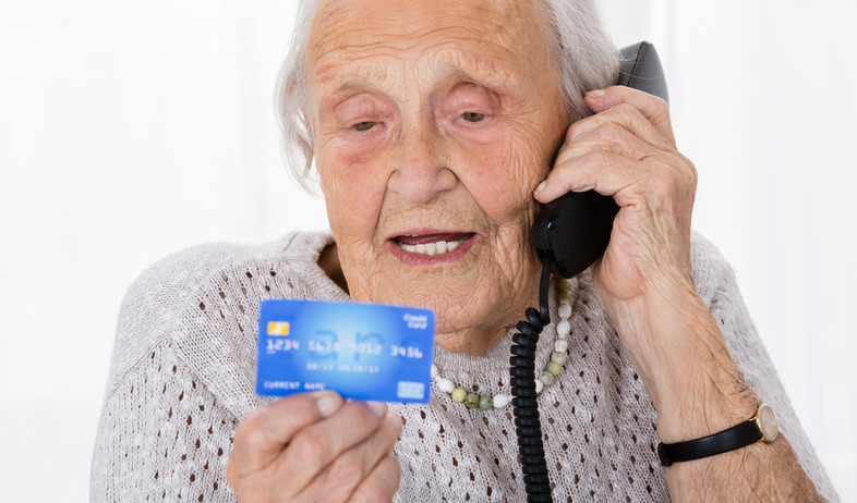 קשישה מדברת בטלפון ומחזיקה כרטיס אשראי (אילוסטרציה: By Dafna A.meron, shutterstock)