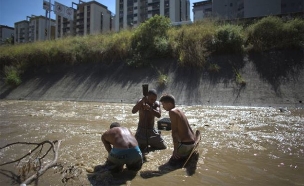 תושבי ונצואלה מחפשים עתיד בנהר המזוהם (צילום: AP)