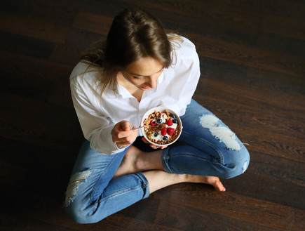 אישה אוכלת יוגורט עם גרנולה (צילום: shutterstock)