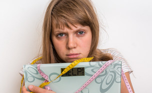 אישה מתוסכלת עם משקל (צילום: shutterstock)