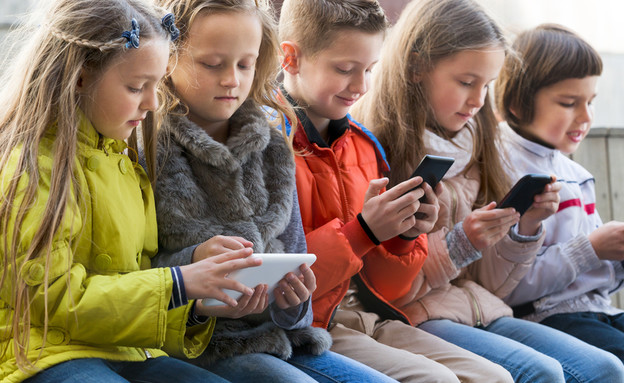 ילדים משחקים בסמארטפון (צילום: Iakov Filimonov, Shutterstock)