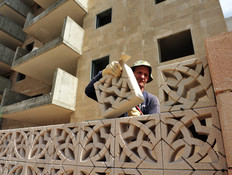 פועל מניח לבנים באתר בנייה באשדוד