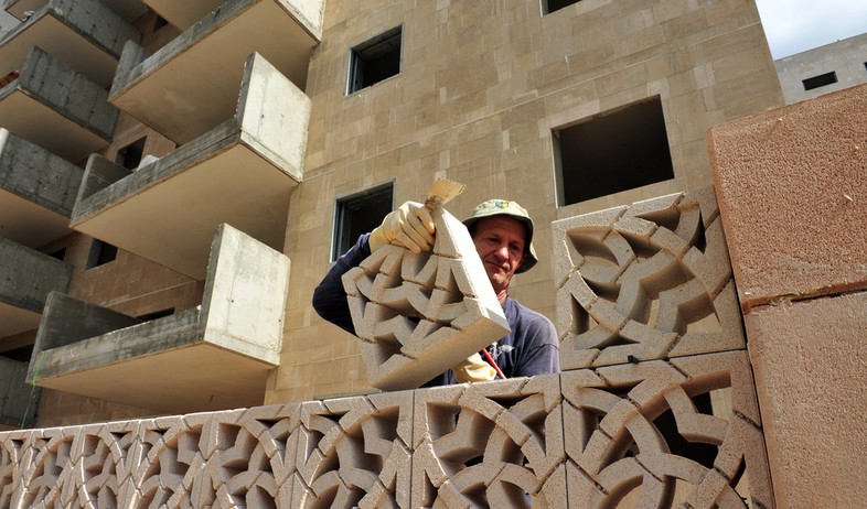 פועל מניח לבנים באתר בנייה באשדוד (אילוסטרציה: By Dafna A.meron, shutterstock)