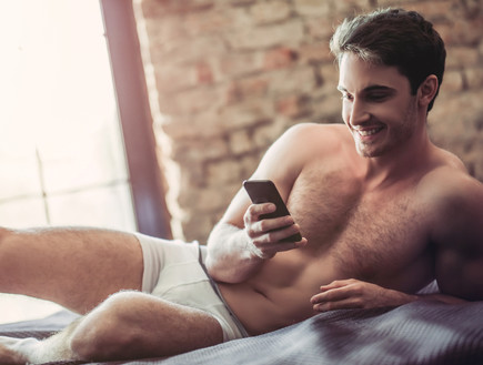 גבר במיטה עם טלפון (צילום: 4 PM production, Shutterstock)