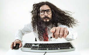 גבר עם שיער ארוך וזקן משתמש במקלדת ועכבר (צילום: conrado, Shutterstock)