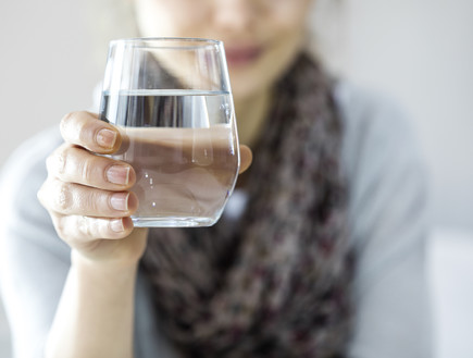 אישה מחזיקה כוס מים  (צילום: shutterstock)