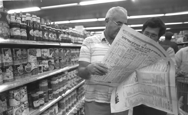 זוג קונים משווים את מחירי המוצרים במדפי סופרמרקט בירושלים ללוח... (צילום: הרמן חנניה - לע"מ)