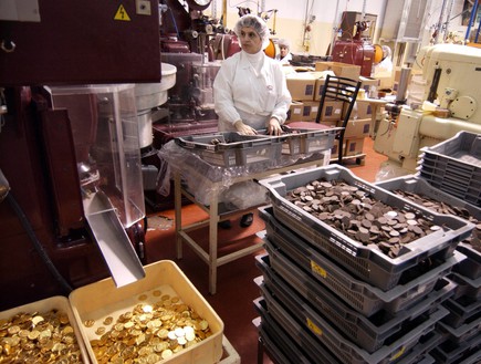 עובדת במפעל עלית בנצרת משגיחה על פס הייצור של מטבעות שוקולד (צילום: עמוס בן גרשום - לע