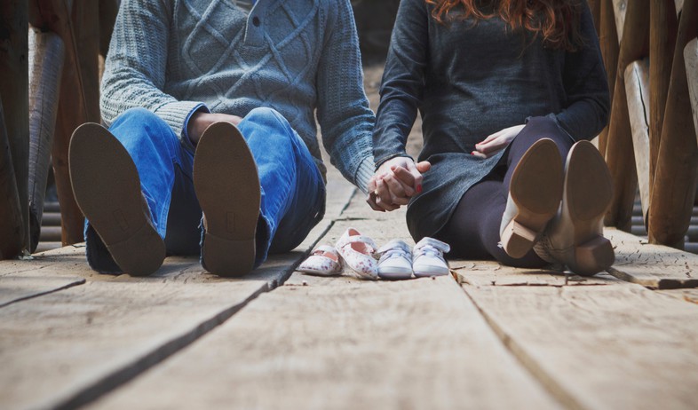 זוג מחזיק ידיים כשמולם נעלי ילדים (אילוסטרציה: unsplash)