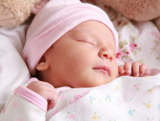 תינוקת ישנה על הגב מחייכת (צילום: אימג'בנק / Thinkstock)