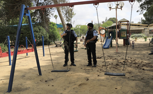 שוטרים שומרים על גן משחקים בקיבוץ בעוטף עזה (צילום: Tsafrir Abayov, ap)