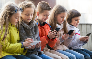ילדים משחקים בסמארטפון (צילום: Iakov Filimonov, Shutterstock)