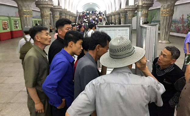 סביב העיתון בתחנת הרכבת בפיונג יאנג (צילום: AP, חדשות)