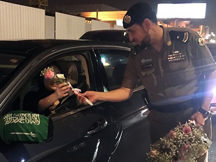 שוטרים מחלקים לנהגות החדשות פרחים (צילום: מתוך אל ע'רבייה, חדשות)