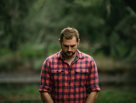 גבר בחולצה משובצת אדומה (צילום: louis-blythe-unsplash)