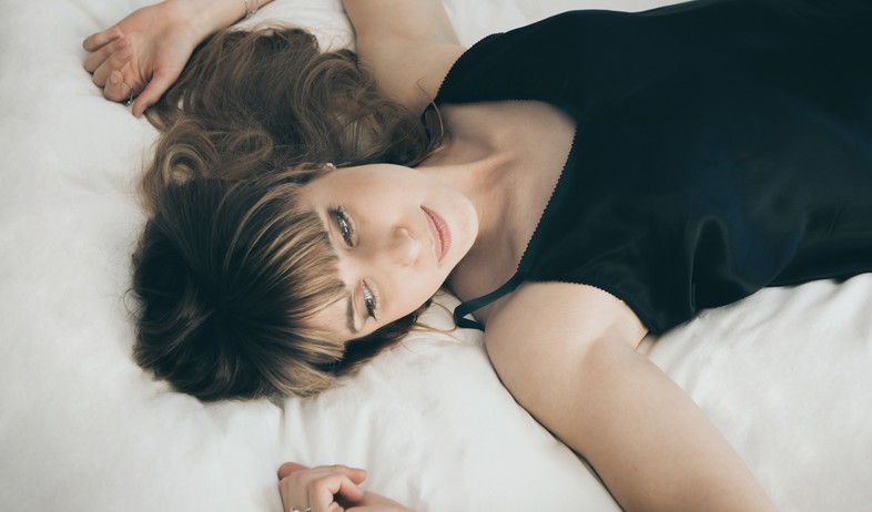 אישה שוכבת במיטה (צילום: nick karvounis on unsplash)