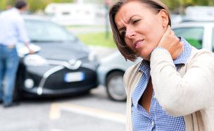 אישה מחזיקה בעורפה אחרי תאונת דרכים (אילוסטרציה: By Dafna A.meron, shutterstock)