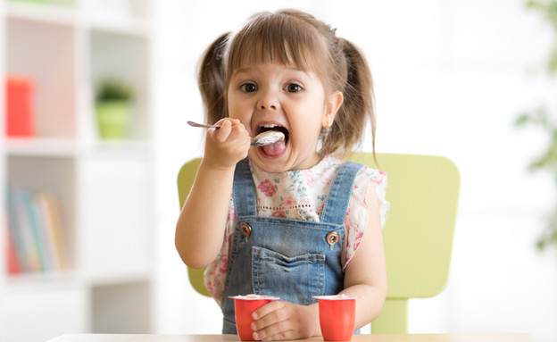 ילדה אוכלת יוגורט (אילוסטרציה: By Dafna A.meron, shutterstock)