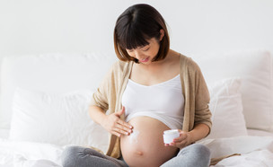 אישה בהריון יושבת ומחזיקה את הבטן (צילום: By Dafna A.meron, shutterstock)