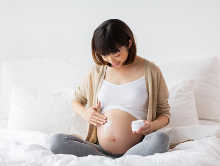 אישה בהריון יושבת ומחזיקה את הבטן (צילום: By Dafna A.meron, shutterstock)