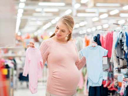 אישה בהריון קונה בגדים לילדים (צילום: By Dafna A.meron, shutterstock)