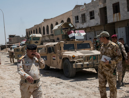חיילים וקצינים עיראקים בפאתי מוסול (צילום: Martyn Aim, stringer)