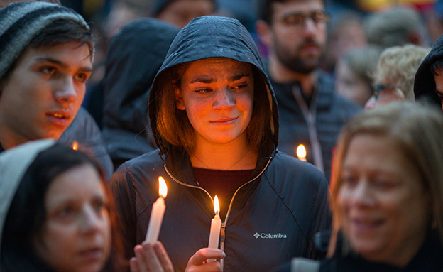 תושבים מדליקים נרות לזכר הנרצחים (צילום: רויטרס, חדשות)