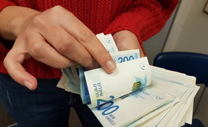 אישה סופרת כסף (צילום: מערכת mako כסף)