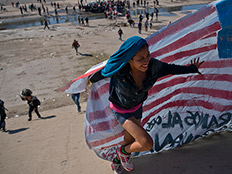 מהגרת על הגבול - עם דגל ארה"ב (צילום: AP, חדשות)