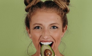 אישה אוכלת אבוקדו (צילום: noah-buscher-unsplash)