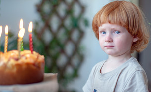 ילד ג'ינג'י עצוב ליד עוגת יום הולדת (אילוסטרציה: By Dafna A.meron, shutterstock)