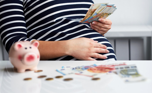 אישה בהיריון עם שטרות כסף (אילוסטרציה: By Dafna A.meron, shutterstock)